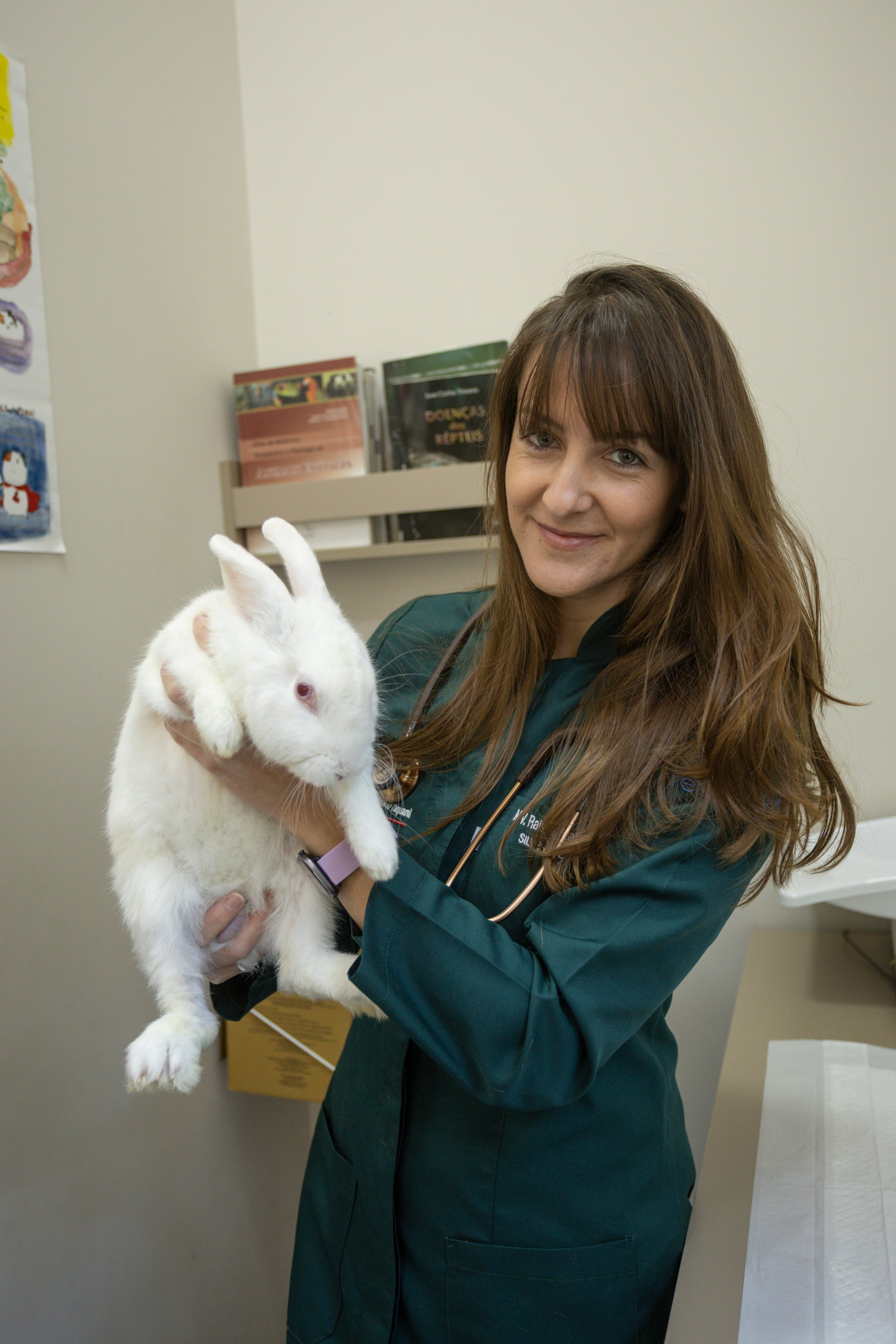 Veterinária Raíssa Natali segurando coelho branco no Hospital Veterinário Taquaral
