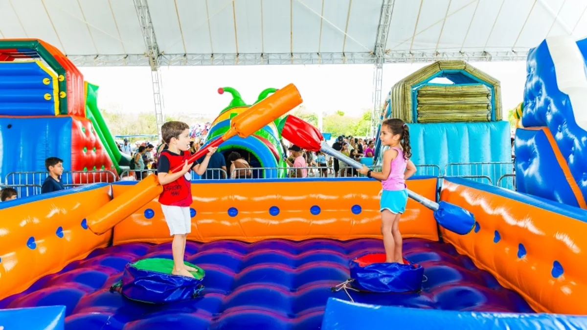 Crianças brincando em brinquedos infláveis coloridos